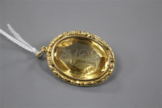 A late Victorian gilt metal mounted oval citrine pendant, engraved with a crested initial,